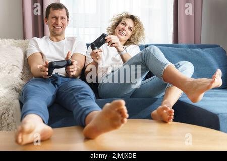 Junge glückliche Paar spielen Videospiel-Konsole Stockfoto