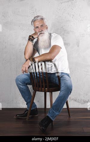 Gutaussehender bärtiger älterer Mann, der im Studio posiert Stockfoto