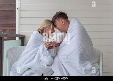Glückliches Paar trinken Decke Kerl Mädchen niedlich verheiratet junge Familie, für Wärme romantisch für Glück und Freizeit Ehemann, Schlafzimmer amourös. Frauen positiv Stockfoto