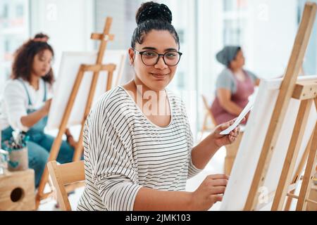 Ich bin am glücklichsten, wenn ich Male. Zugeschnittenes Porträt einer attraktiven jungen Frau, die mit ihren Freunden sitzt und während eines Kunstkurs in der malt Stockfoto