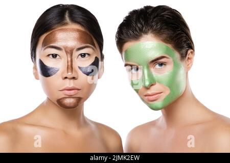 Zwei schöne Mädchen mit bunten Abziehmasken auf ihren Gesichtern Stockfoto