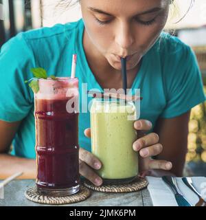 Die Frau verkostet verschiedene gesunde Getränke in einem veganen Café Stockfoto