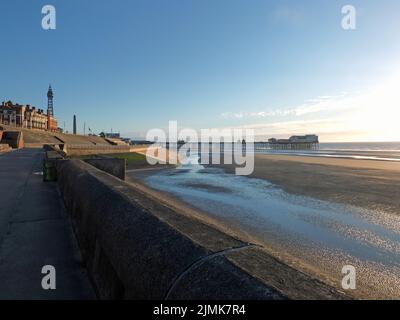 Blick auf den blackpool Tower und den Südpier von der Promenade mit Stadtgebäuden bei Nachmittagssonne Stockfoto