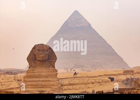 Blick auf Sphinx im Gizeh Plateau mit der Großen Pyramide von Gizeh im Hintergrund. Stockfoto