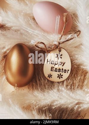 Frohe Ostern. Goldenes osterei auf rustikalem Hintergrund, christlicher Religion und Feiertag Stockfoto