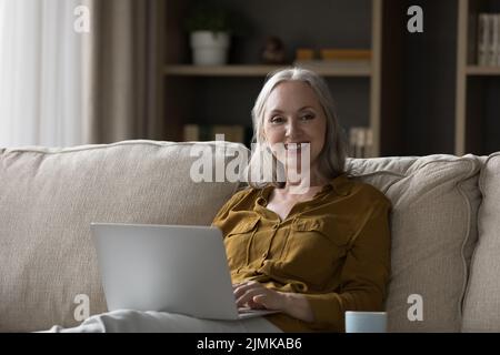 Glücklich reif im Ruhestand hübsche Frau mit Laptop Stockfoto