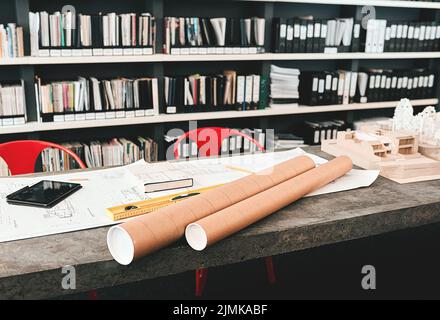 Willkommen in der Ecke der Kreativität. Stillleben eines Architekten Blaupausen auf einem Schreibtisch in einem modernen Büro platziert. Stockfoto