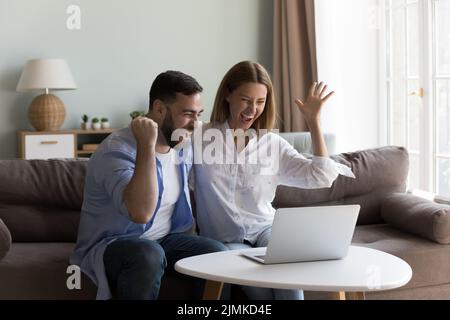 Junges Paar fühlen sich überglücklich erhalten große Online-Nachrichten Stockfoto