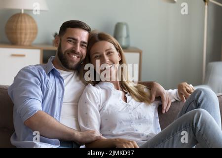 Schöne Ehepartner posieren für Kamera auf dem Sofa zu Hause sitzen Stockfoto