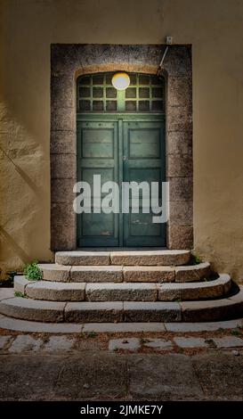 Doppelte Holztür mit Lampe beleuchtet. Stockfoto