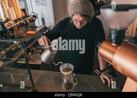 Hand Filterkaffee, Barista gießt Wasser auf Kaffee boden mit Filter Stockfoto