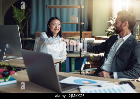 Zwei glückliche Kollegen klatschen nach Abschluss der Projektarbeit in die Hände Stockfoto