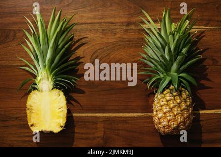 Flache Laie von Ananasfrüchten auf Holzoberfläche Stockfoto