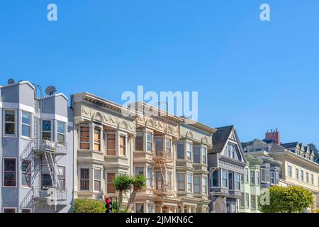 Stadthäuser Nachbarschaft außen mit Blick auf Ampeln und Bäume an der Vorderseite. Nachbarschaft in San Francisco, Kalifornien mit Bogenfenstern und Stockfoto