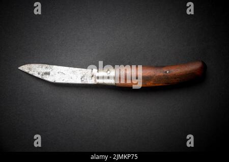 Traditionelles Holztaschenmesser auf schwarzem Hintergrund Stockfoto