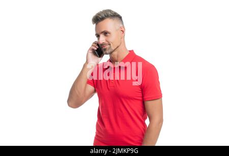 Reifer Mann in rotem T-Shirt spricht auf Smartphone isoliert auf weißem Hintergrund Stockfoto