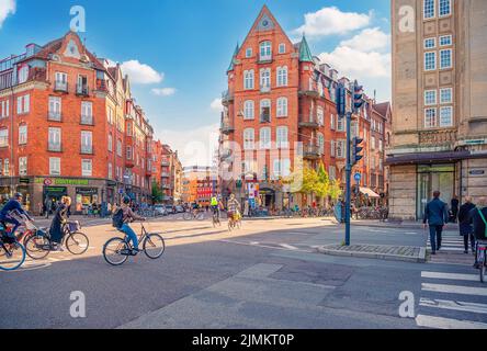 Große Straße Gathersgade mit alten Backsteinhäusern, viele Radfahrer, Fußgänger und Autos in Kopenhagen, Dänemark Stockfoto