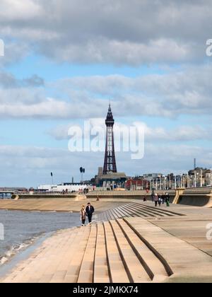 Malerischer Blick auf blackpool aus dem Süden mit Wellen, die auf den Stufen brechen, Menschen auf der Promenade und der goldenen Meile und dem Turm Stockfoto