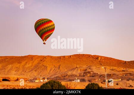 Am Morgen fliegen farbenfrohe Heißluftballons über das Tal der Könige. Stockfoto