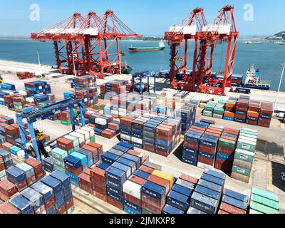 LIANYUNGANG, CHINA - 7. AUGUST 2022 - Luftfoto vom 7. August 2022 zeigt das Be- und Entladen von Import- und Exportgütern am Container te Stockfoto