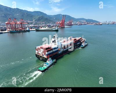 LIANYUNGANG, CHINA - 7. AUGUST 2022 - Luftfoto vom 7. August 2022 zeigt das Be- und Entladen von Import- und Exportgütern am Container te Stockfoto