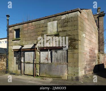 Verlassene leere verlassene Geschäftsräume, die aus einem Haus mit einstürzenden Wänden und vertauften Türen und Fenstern umgebaut wurden Stockfoto