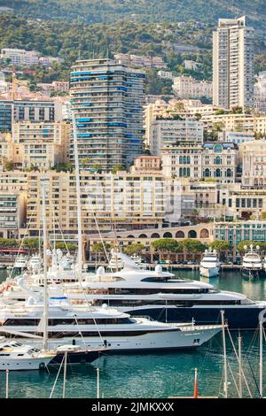 Luftaufnahme des Hafens Hercules bei Sonnenuntergang, Megayachten sind in der Marina in der Nähe des Yachtclubs von Monaco vertäut, Blick auf das Stadtleben von der alten T Stockfoto