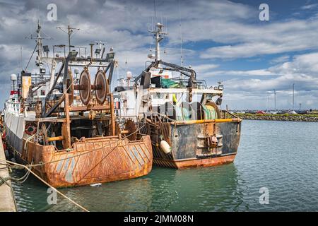 Zwei alte und rostige Fischerboote vertäuten im Hafen von Howth, Dublin, Irland Stockfoto