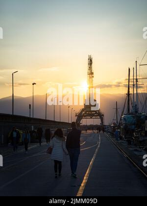 Rijeka-Eisenbahn auf dem großen Maulwurf mit Schiffen und Kran bei Sonnenuntergang Stockfoto