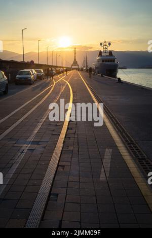 Rijeka-Eisenbahn auf dem großen Maulwurf mit Schiffen und Kran bei Sonnenuntergang Stockfoto