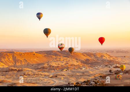 Blick auf bunte Heißluftballons, die über das Tal der Könige fliegen. Stockfoto