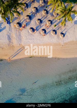 Drohnenblick auf einen Strand von oben in Mauritius, Drohnenblick mit Sonnenschirm und Sonnenbank auf dem ebach Stockfoto