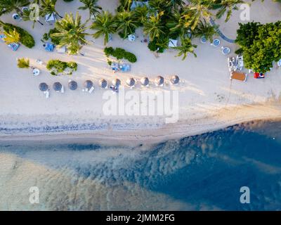 Drohnenblick auf einen Strand von oben in Mauritius, Drohnenblick mit Sonnenschirm und Sonnenbank auf dem ebach Stockfoto