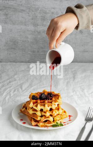 Nahaufnahme von Hand Gießen Sirup Stockfoto