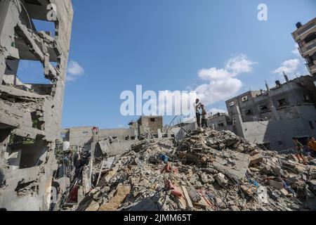 Rafah, Palästinensische Gebiete. 07. August 2022. Palästinenser inspizieren die Trümmer eines Gebäudes, in dem Khaled Mansour, der Kommandeur des südlichen Islamischen Jihad, nach einem israelischen Luftangriff in Rafah im südlichen Gazastreifen getötet wurde. Kredit: Mohammed Talatene/dpa/Alamy Live Nachrichten Stockfoto