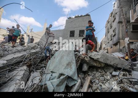 Rafah, Palästinensische Gebiete. 07. August 2022. Palästinenser inspizieren die Trümmer eines Gebäudes, in dem Khaled Mansour, der Kommandeur des südlichen Islamischen Jihad, nach einem israelischen Luftangriff in Rafah im südlichen Gazastreifen getötet wurde. Kredit: Mohammed Talatene/dpa/Alamy Live Nachrichten Stockfoto