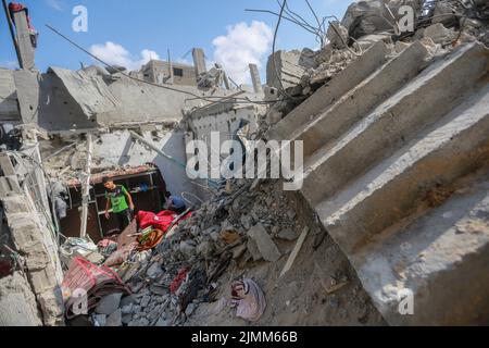 Rafah, Palästinensische Gebiete. 07. August 2022. Palästinenser inspizieren die Trümmer eines Gebäudes, in dem Khaled Mansour, der Kommandeur des südlichen Islamischen Jihad, nach einem israelischen Luftangriff in Rafah im südlichen Gazastreifen getötet wurde. Kredit: Mohammed Talatene/dpa/Alamy Live Nachrichten Stockfoto