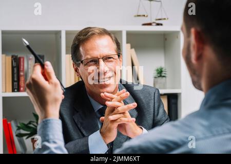 Portrait reif glücklich Rechtsanwalt sitzt mit Client Stockfoto