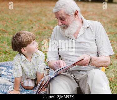 Opa liest Enkelpark Stockfoto