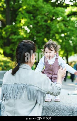 Glückliche Mutter und Tochter spielen auf einer Straße Stockfoto