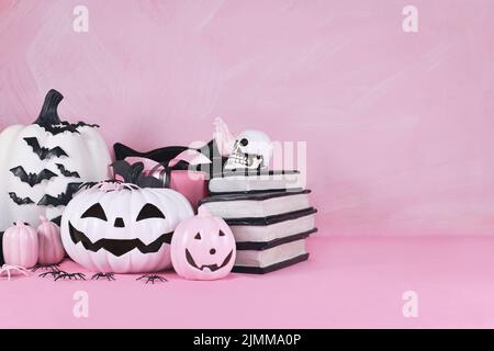 Pinkes Halloween Dekor mit schwarzen und weißen Kürbissen, Zauberbüchern und Spinnen mit Kopierfläche Stockfoto