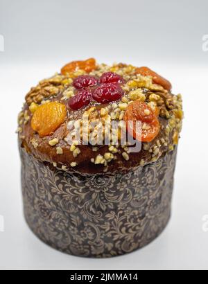 Gebackene Osterkuchen mit getrockneten Aprikosen und Walnüssen vor weißem Hintergrund. Traditionelles Kulich, Paska Osterbrot. Stockfoto