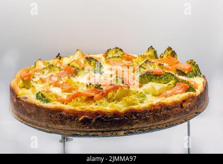 Offener Kuchen mit Lachs und Brokkoli aus der Nähe. Hausgemachte Quiche. Stockfoto