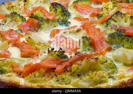 Offener Kuchen mit Lachs und Brokkoli aus der Nähe. Hausgemachte Quiche. Stockfoto