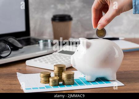 Wachstumskarte für die Hand Putting Coin Piggy Bank Stockfoto