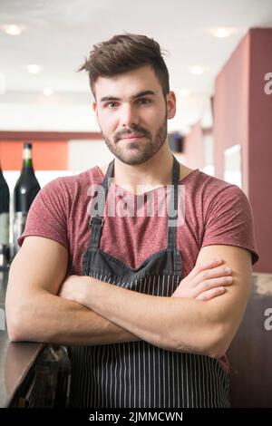 Portrait junger Mann mit Schürze Stehbar Stockfoto