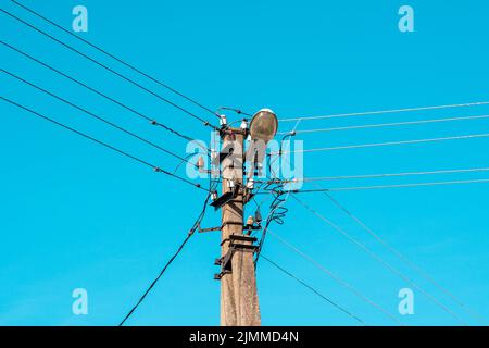 Elektrische Drähte, die mit einer Beleuchtungslampe an einer Stange hängen Stockfoto