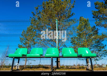 Plastikstühle im Basketballfeld aus einem niedrigen Winkel Stockfoto