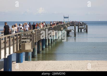 Boltenhagen, Deutschland. 07. August 2022. Bei Sonnenschein und 20 Grad Celsius laufen die Menschen über den Pier. Das Ostseebad Boltenhagen feiert an diesem Wochenende das Seebrückenfest 30.. Quelle: Danny Gohlke/dpa/Alamy Live News Stockfoto