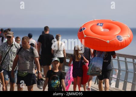 Boltenhagen, Deutschland. 07. August 2022. Bei Sonnenschein und 20 Grad Celsius laufen die Menschen über den Pier. Das Ostseebad Boltenhagen feiert an diesem Wochenende das Seebrückenfest 30.. Quelle: Danny Gohlke/dpa/Alamy Live News Stockfoto